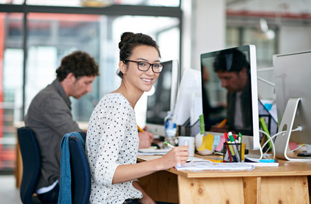 I work for the best company. Portrait of a beautiful young woman working at her desk in an office.