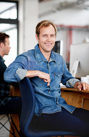 Ready to put your designs into reality. Portrait of a designer sitting at his desk in an office.