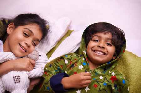 It was an awesome day of fun but now were tired. two siblings lying next to each other on a bed.の写真素材