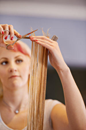 Taking care of split-ends. a female hairdresser cutting a clients hair.の写真素材