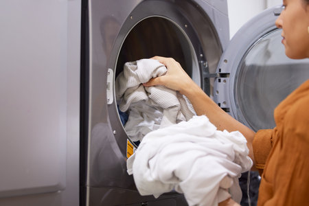 Laundry, cleaning and woman with clothes in the washing machine for housekeeping, clean fabric and...