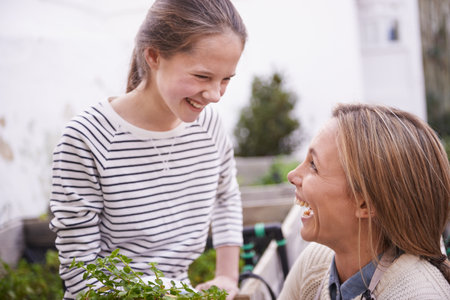 Organic fun. a mother and daughter gardening together in their backyard.の写真素材