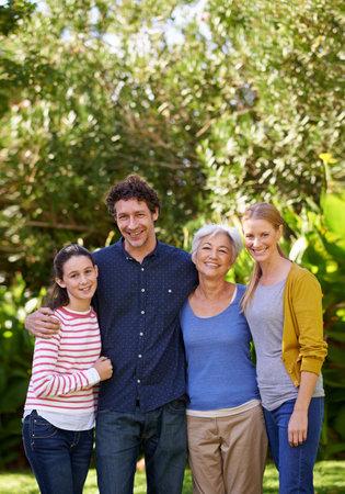 Visiting Grandma. Portrait of a happy multi-generational family standing together in a garden.の写真素材