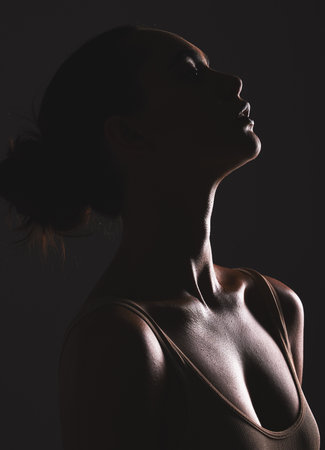 Woman beauty silhouette, face and dark, sexy with cosmetics and seductive fantasy with mysterious aesthetic. Female profile with skin, sexy woman facial and shadow against black studio background.の写真素材