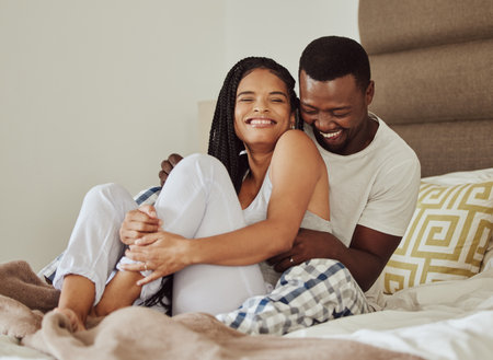 Love, black couple on bed and play together for bonding, loving and romantic weekend. Romance, man and woman in bedroom, morning and silly on break, relationship and happiness for marriage and smileの写真素材