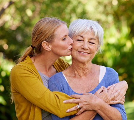 Her greatest inspiration. a young woman kissing her mother on the cheek.の写真素材