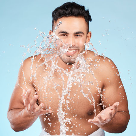 Cleaning, water splash and portrait of man happy with self care routine, facial hygiene and body hygiene wash. Water drop, bathroom skincare hydration and beauty model with health wellness treatmentの写真素材