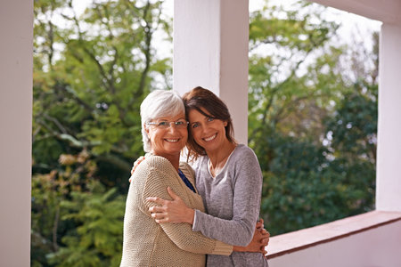 Daughters grow up to be their moms best friends. A cropped portrait of a happy senior woman standing at home with her daughter.の写真素材