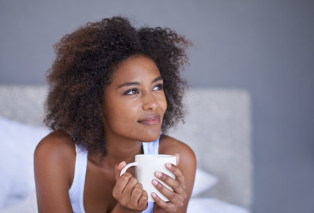 Not a care in the world this morning. a young woman enjoying a cup of coffee.