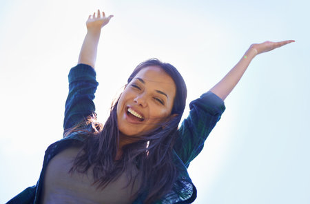 Celebrating life. Portrait of an attractive young woman celebrating the day outside.の写真素材