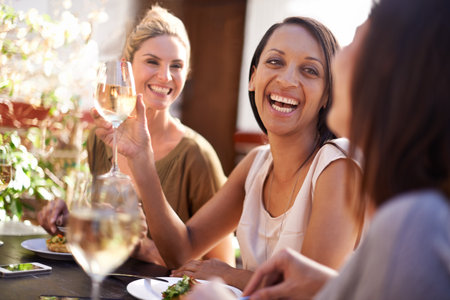 Girls just wanna have fun. a happy group of friends having a drink together.の写真素材