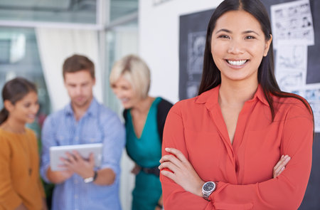 Shes a team player. A portrait of a happy businesswoman standing in an office with her coworkers in...