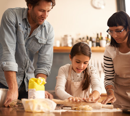 Fun for the whole family. a young family having fun baking in a kitchen.の写真素材