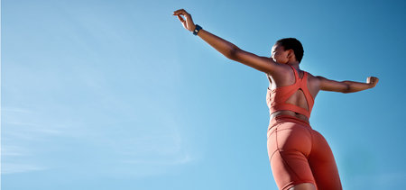 Woman, arms up or fitness success on blue sky background in workout, training or exercise goals for...
