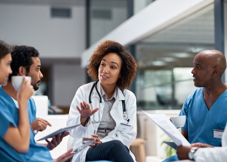 Having a work related chat with the colleagues. a group of young doctors having a meeting over...