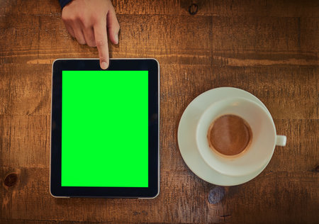 It takes one touch to connect. High angle shot of an unrecognizable man using a digital tablet with a green screen in a cafe.の写真素材