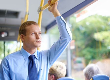 Businessman on the bus. a young businessman commuting to work.の写真素材