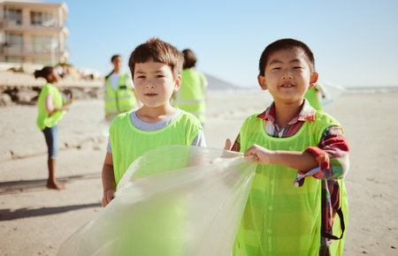 Children, portrait or trash collection bag in beach waste management, ocean cleanup or sea community service. Happy kids, climate change or cleaning volunteering plastic for nature recycling bondingの写真素材