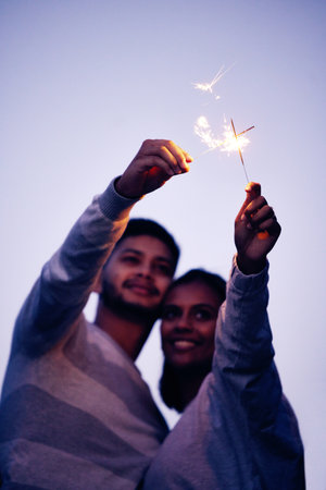 Couple, sparklers and happy together for night celebration or romance date for love, support and freedom outdoor. Smile, Indian woman and man hugging or quality time to celebrate happiness in Baliの写真素材