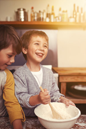 Baking with a smile. two young brothers baking in the kitchen.の写真素材