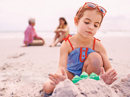 Nurturing her imagination. Portrait of a little girl playing at the beach.の写真素材