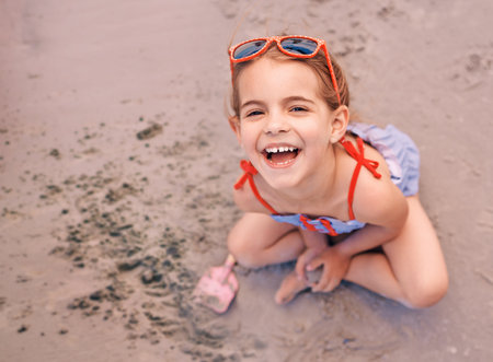 Leaving her mark on the beach. Portrait of a smiling little girl at the beach.の写真素材
