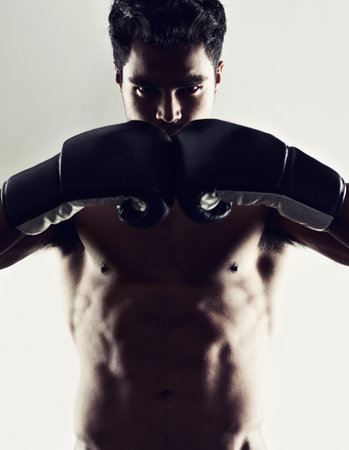 Hes dedicated to the sport of boxing. Portrait of a young male boxer in a fighting stance.