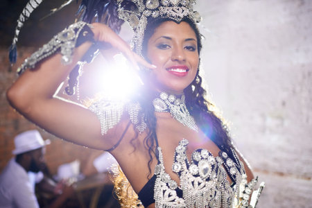 Performing a live show. Portrait of a young female dancer with her band sitting in the background.