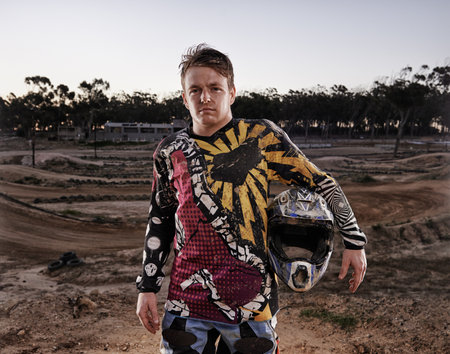 Passion comes with a bit of dirt. Portrait of a dirtbike race standing in his race gear.の写真素材