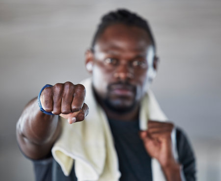 Fist, boxer and martial arts with black man and fitness, sports and boxing with exercise and hand zoom. Athlete, wellness and MMA fighter with towel, workout and training with sport motivationの写真素材