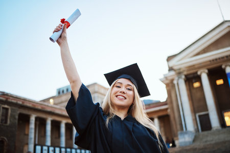Education, graduation and portrait of woman at university, college and academic campus with diploma certificate. Celebration, graduate ceremony and girl student with success, victory and achievementの写真素材