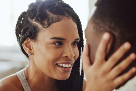Black couple, face and smile in morning, bedroom and love with bonding, care and romance in home. Happy couple, eye contact and together for happiness, holiday or vacation in hotel, room or houseの写真素材