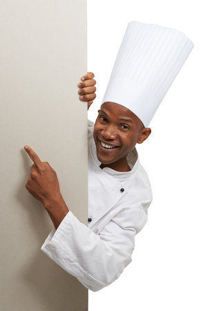 Advertising his new restaurant. Portrait of an african chef standing behind copyspace.の写真素材