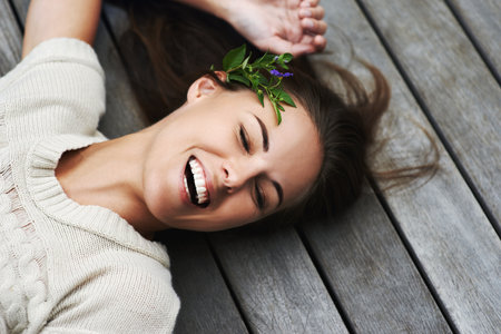Filled with positive natural energy. An attractive young woman lying on her porch.の写真素材