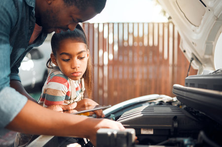 Father, tablet and child learning about car problem with diagnostic software for mechanic repair. Black man and daughter or girl bonding while working on engine using online tools for family vehicleの写真素材