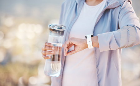 Woman, runner and smartwatch check with water bottle, heart check with fitness, cardio and run...