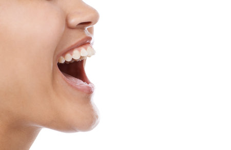 Laughing from her stomach. Closeup of a womans mouth laughing against a white background.