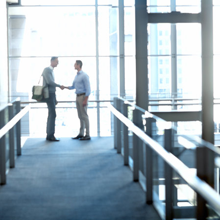 Business men, handshake or greeting in hotel lobby, modern office or airport lounge in CRM team meeting. Corporate workers, employees or shaking hands in partnership deal, collaboration or agreementの写真素材