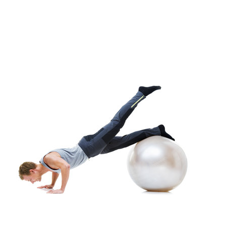 Hes got perfect balance. a man balancing on an exercise ball with a white background.の写真素材