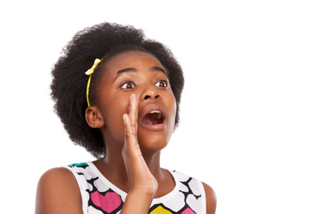 Listen up. Head and shoulders studio shot of a young african american girl shouting isolated on white.の写真素材