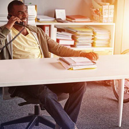 Lets set up an appointment. a young businessman talking on his phone in the office.の写真素材