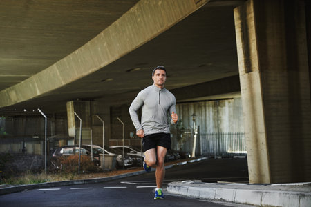 Keeping the heart pumping. Fit young man going for a run in the city.