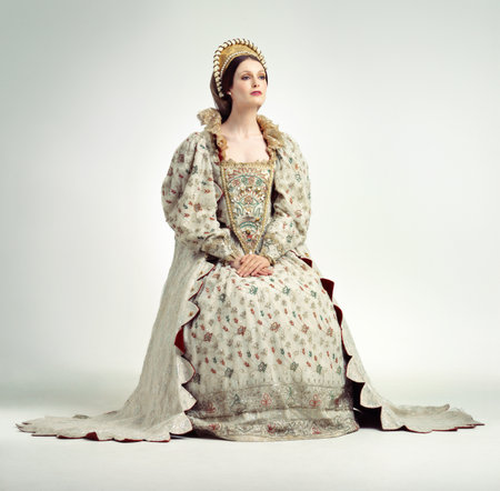 Queen, crown and vintage with a woman in studio on a gray background as ruler of the monarch during the renaissance period. History, royalty and victorian with an elegant female posing as a leaderの写真素材