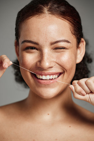 Teeth flossing, dental floss and portrait of woman with a smile in studio for oral hygiene, health...