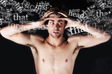 Hes hearing voices. A young man holding his head surrounded by words.