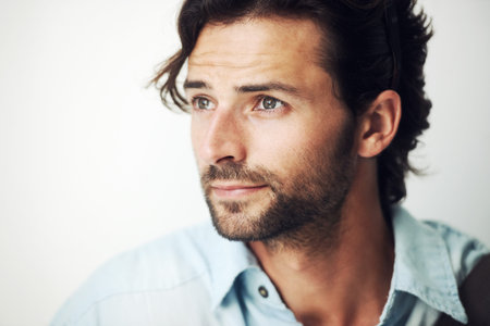 Face, thinking and inspiration with a handsome man on a gray background with blank mockup space....