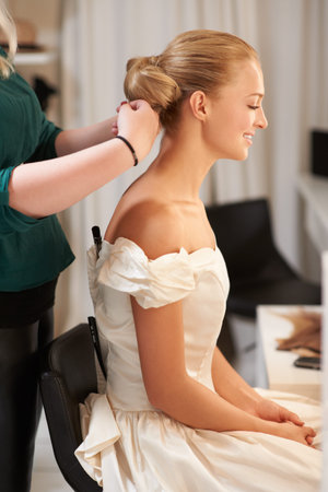 Getting ready for the happiest day of her life. A young bride getting her hair done before the...