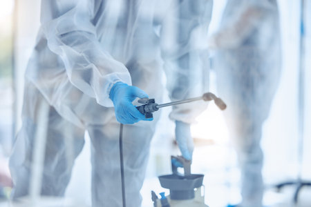 Closeup on hand of biohazard cleaner using antiseptic equipment. Closeup of science team cleaning a...