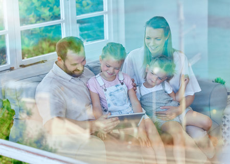 This is so fascinating. a young family using a digital tablet together at home.