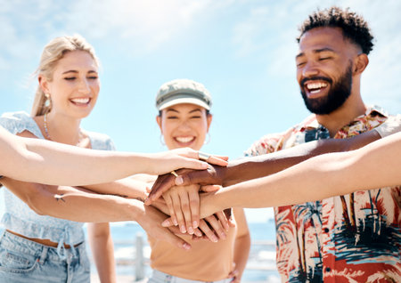 Let the fun begin. a diverse group of friends standing together and stacking their hands in the middle.の写真素材